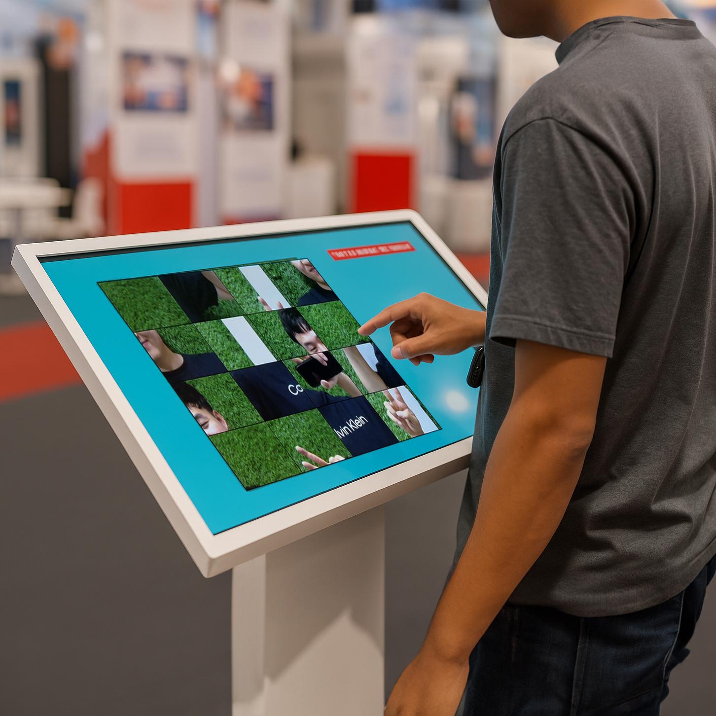 Guest solving a scrambled photo puzzle on a touchscreen at an event. Interactive image puzzle game rental for exhibitions, corporate events, and activations in Dubai.